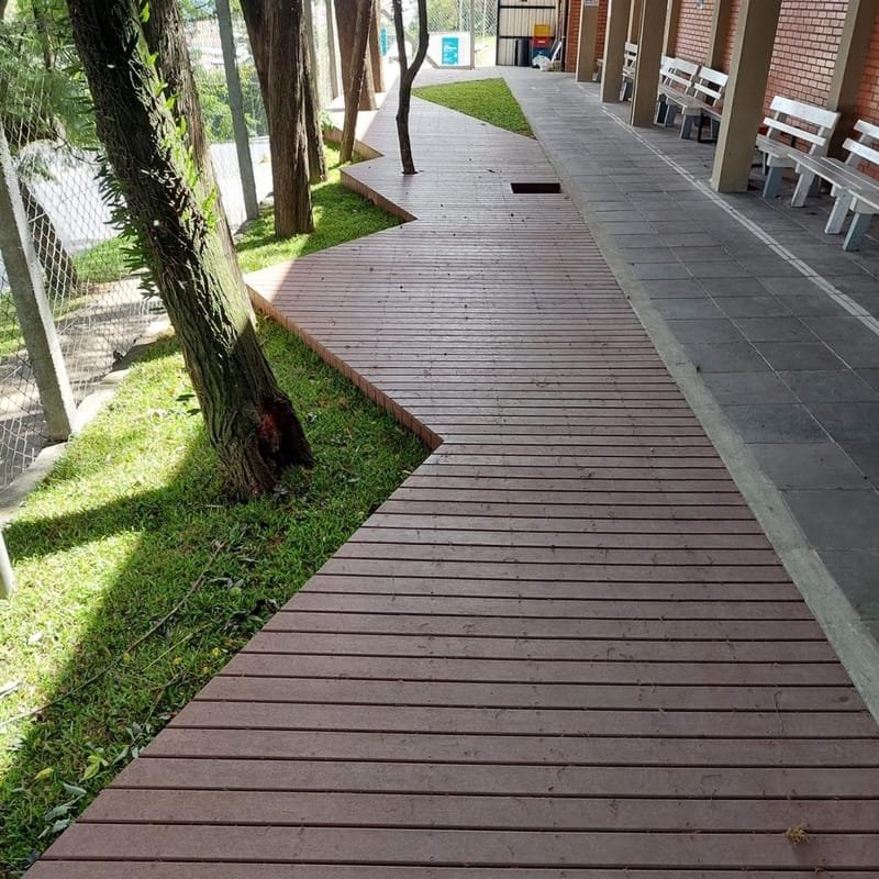 Passarela em deck de madeira ecológica em zigue-zague junto à portaria de condomínio