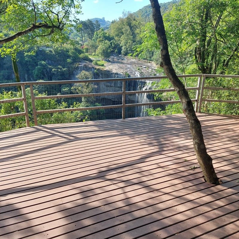 Deck mirante em madeira plástica maciça com árvore preservada e vista para a serra