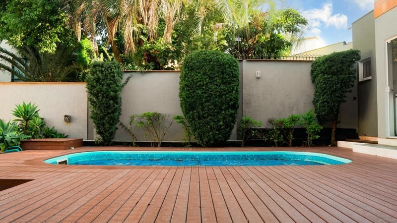 Deck de piscina em madeira ecológica cor ipê em residência com jardim, Rio de Janeiro