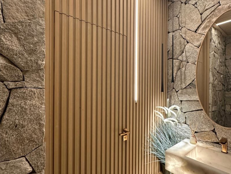 Painel EcoRipado de madeira ecológica com pedra natural e iluminação em lavabo