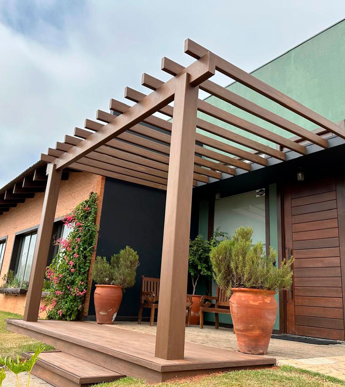 Pergolado Linha Prime EcoÚtil instalado sobre deck na entrada de uma casa